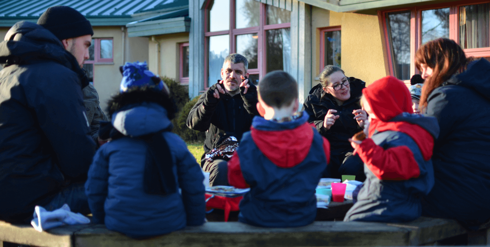 Children sitting together and singing at Nature Nurture