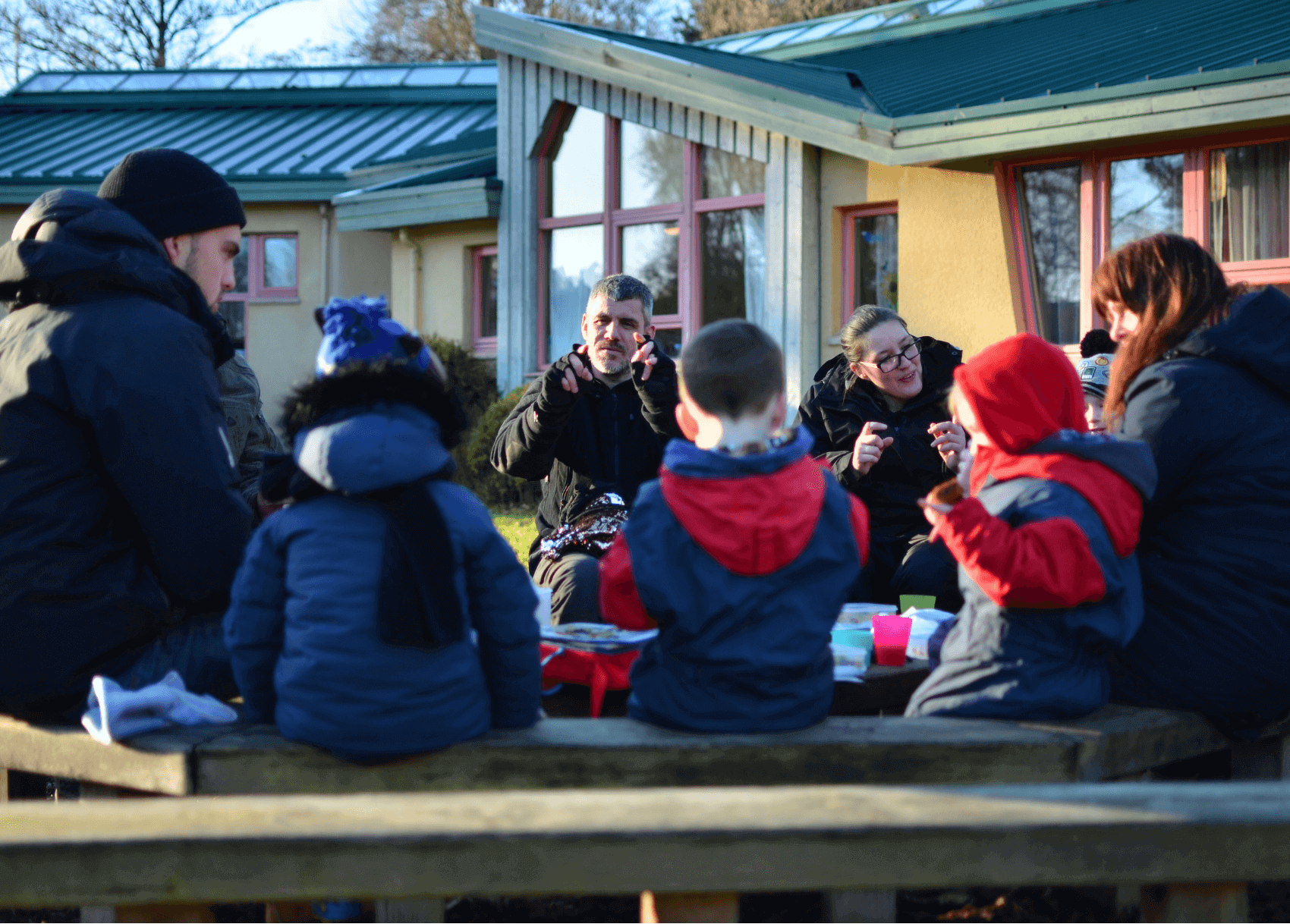 Children sitting together and singing at Nature Nurture