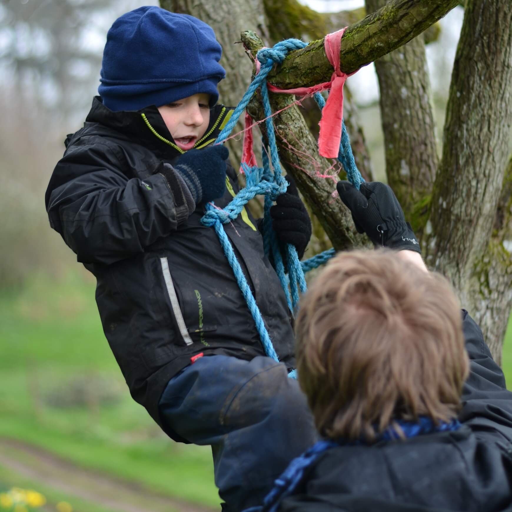 Child climbing a tree with rope at Nature Nurture