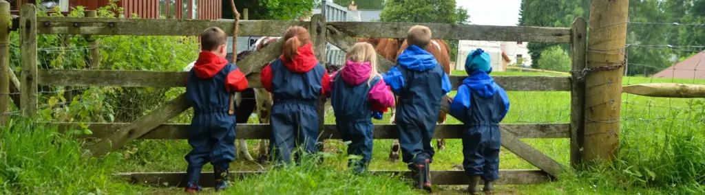 Children stand together at field gate