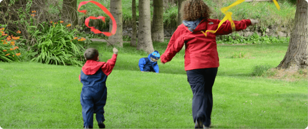 Adult and child running with streamers