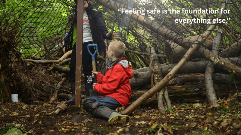 Feeling safe is the foundation of everything else – Two children inside a den made from branches and netting.