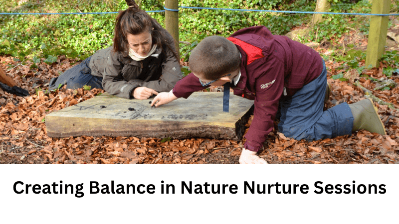 Creating Balance in Nature Nurture Sessions – adult and child on ground drawing on a log with charcoal.