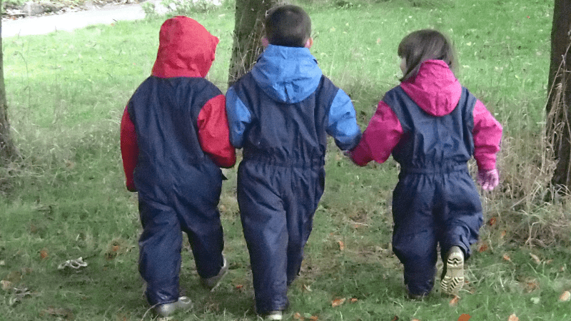 three children walking together hand in hand