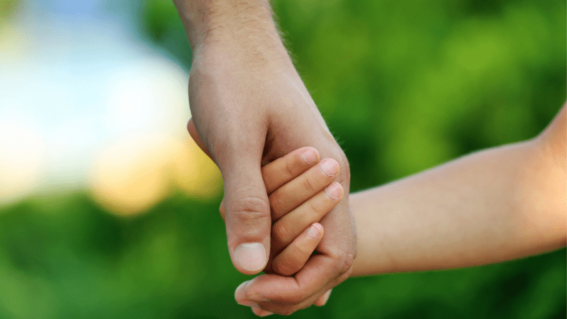 transitions child holding an adults hand