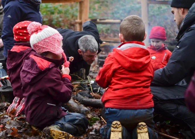 Children toasting marshmallows around a fire at Nature Nurture